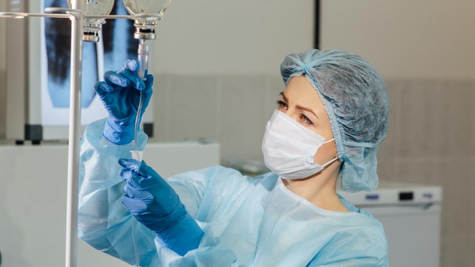 A healthcare worker checks IV equipment